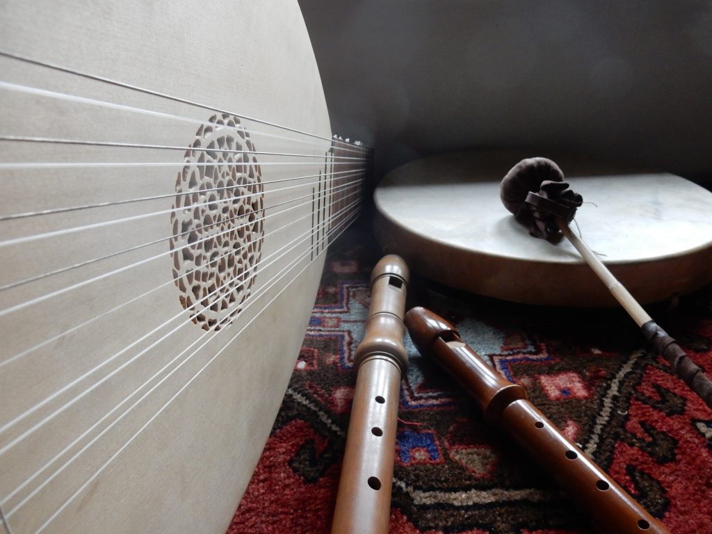 A close up photo of a lute, 2 whistles and a small drum
